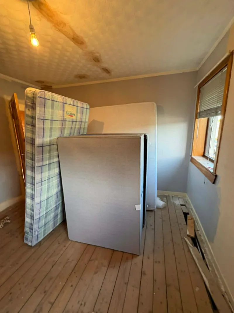 A cleared bedroom with a mattress and divan base ready for collection